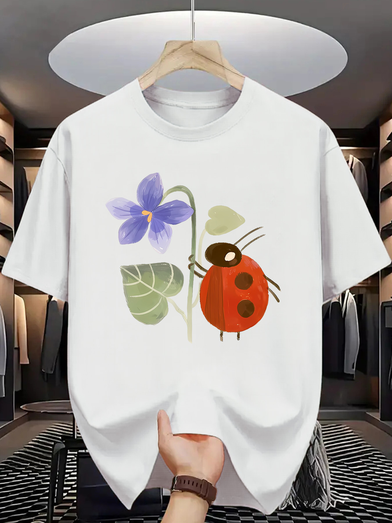 Men's Graphic T-Shirt Whimsical Garden Flower With Leaves Beside A Playful Red Ladybug